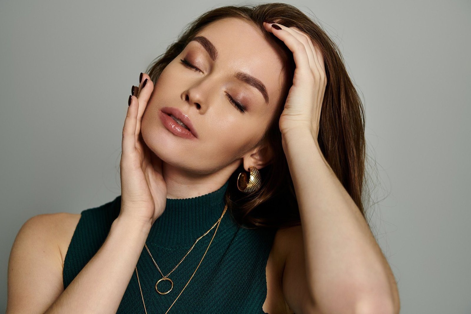 Woman in a green top wearing gold jewellery